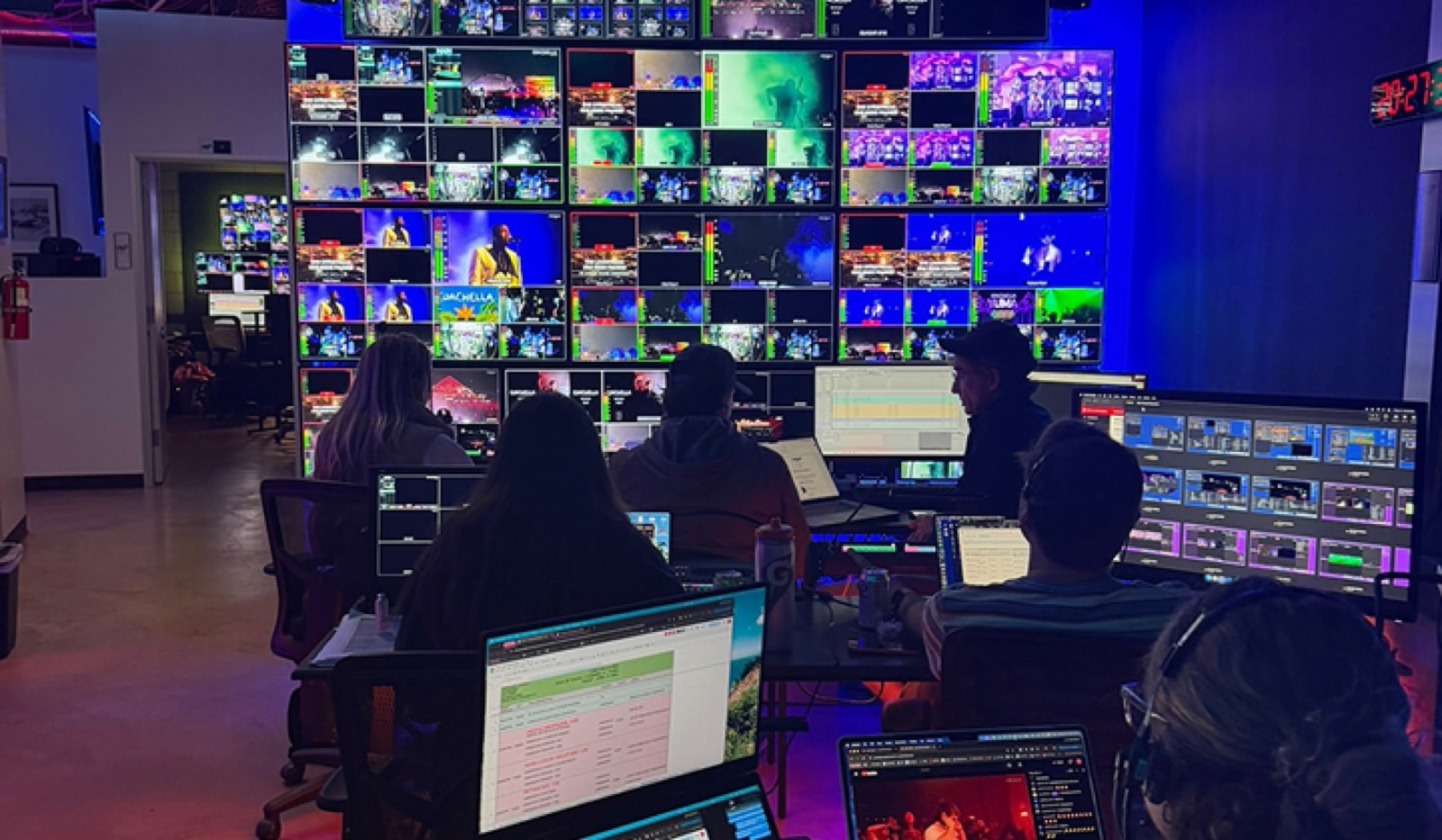 Broadcast operators at a wall of monitors during a livestream